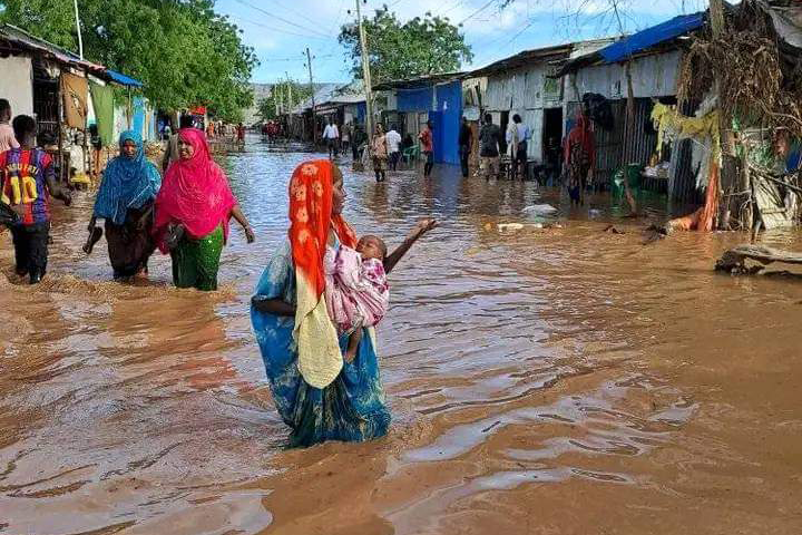 A mother with her baby stand in flood water in Kelafo, Ethiopia during flooding in the Horn of Africa